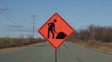 construction orange traffic sign on rural road clouds time lapse
