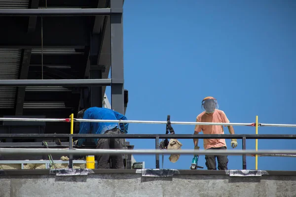 construction site workers on roof roofing metal structure men builders