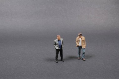 Gri arka planda havalı adamların eğlenceli mini figürleri
