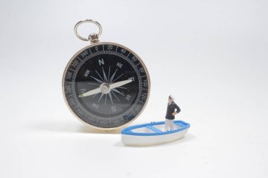 Küçük tekne ve kaptan figürlü pusula.