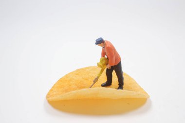 Patates cipsi temizleyen işçi figürü.