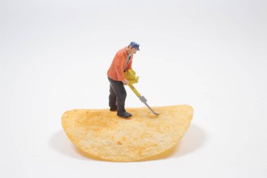 Patates cipsi temizleyen işçi figürü.