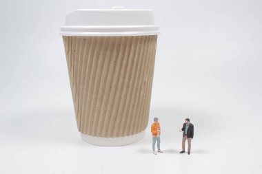 Beyaz arkaplanda izole edilmiş bardaklı mini figürler