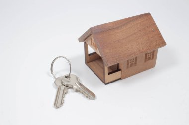 Küçük ahşap ev ve gümüş anahtarlar.