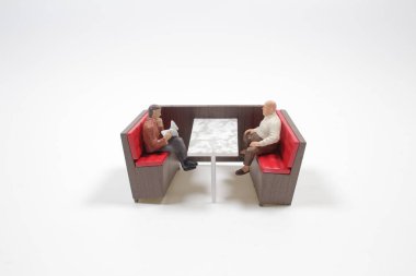 Mini restoran masasındaki küçük insan figürleri.