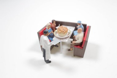 Mini restoran masasındaki küçük insan figürleri.