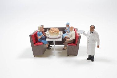 Mini restoran masasındaki küçük insan figürleri.