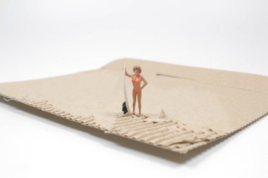 Kartonda genç bir sörfçü figürü