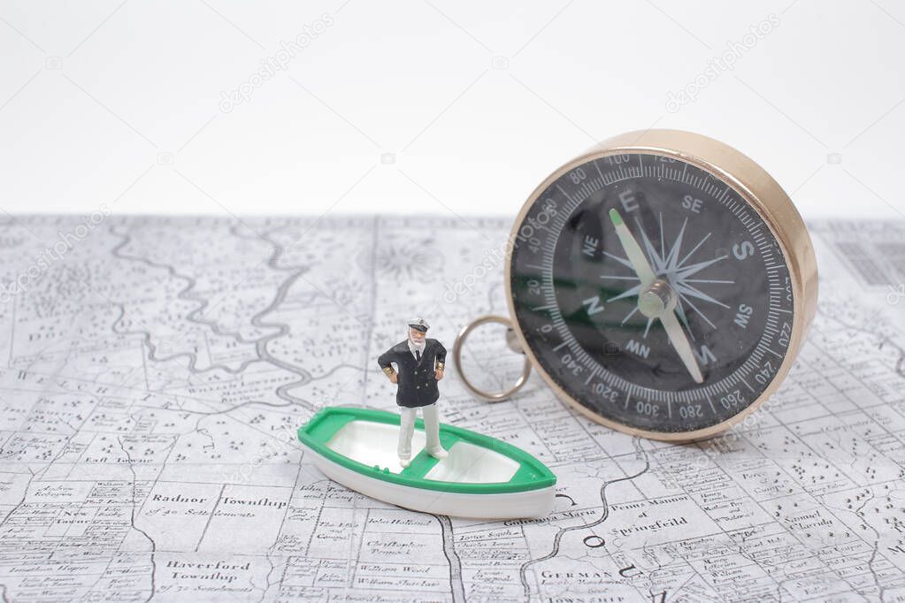Mini of captain on the boat with compass and map