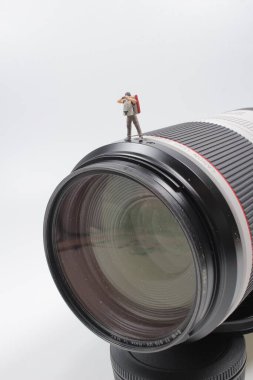 Kameranın objektifinde duran mini fotoğrafçı.