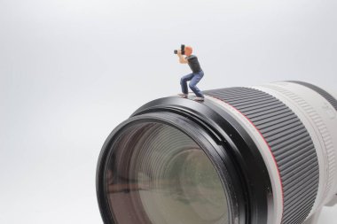 Kameranın objektifinde duran mini fotoğrafçı.