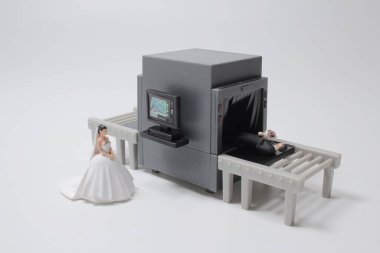 Mini gelin damadı röntgen tarayıcısıyla kontrol ediyor.