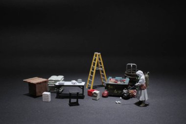 Koruyucu giysili adam çalışma alanını dezenfekte ediyor.