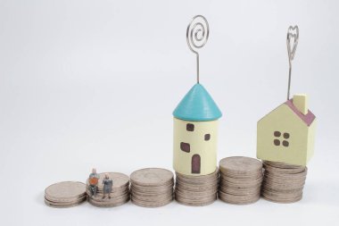 Yığınla madeni paranın üzerinde küçük bir evde oturan yaşlılar 