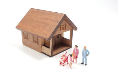 Bir evin önündeki minyatür heykelciklerden oluşan genç bir aile.