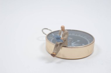 Mini insanlar, iş adamı pusula ile kitap okuyor.