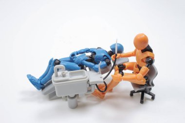  dentist with his assistant examining  patient in dentist office