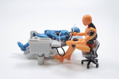  dentist with his assistant examining  patient in dentist office