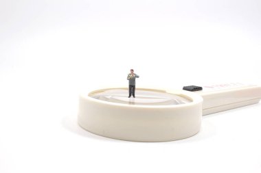 Minyatür insanlar: İş adamı Büyüteçle kitap okuyor. Eğitim ve iş konsepti.