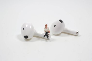 Seyahat, müzik ve hobi konsepti. Oturup kitap okuyan minyatür bir figür.