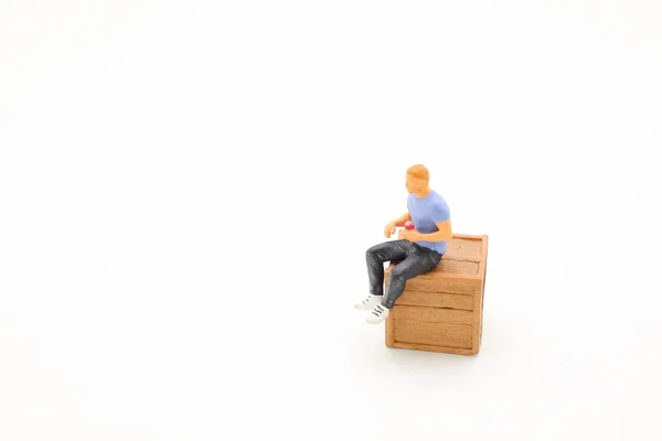 Figura Człowiek Shirt Szare Dżinsy Siedzi Drewnianej Skrzyni — Zdjęcie stockowe