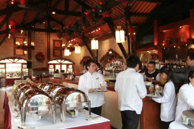 Garsonlar masaya yemek getiriyor ve restoranda servis yapıyor..