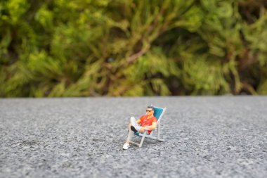 Parkta dinlenen mini figür.