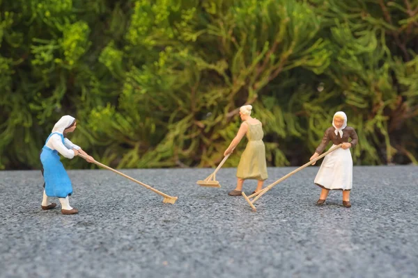 Toprakta çalışan figür çiftçileri