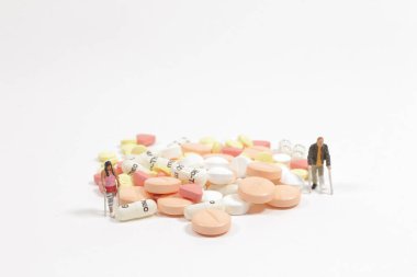 Bir sürü hapı olan bir yaralanma figürü.