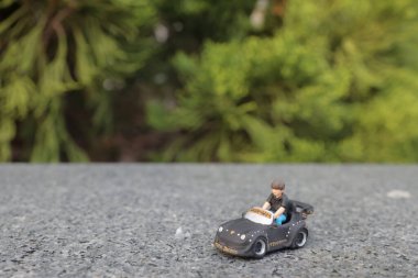 Çocuk büyük oyuncak araba kullanıyor ve oynamakla eğleniyor.