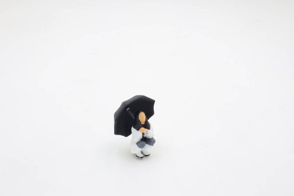 the mini of figure sits under an umbrella