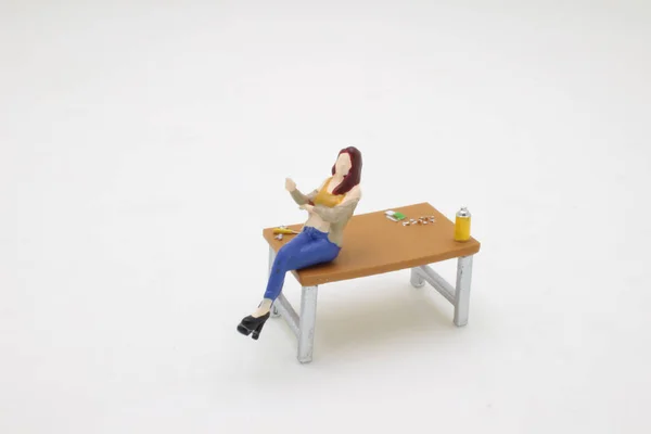 オフィスのテーブルの上に座っている人物のミニ — ストック写真