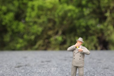 Minyatür iş adamı açık havada sigara içiyor. 