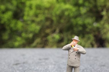 Minyatür iş adamı açık havada sigara içiyor. 