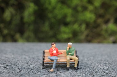 Parktaki bankta sohbet eden mini figür.