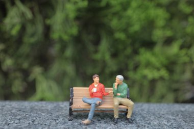 Parktaki bankta sohbet eden mini figür.