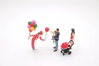 Küçük palyaço, bebekle oyna.