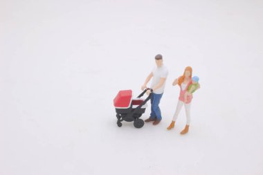 the mini of Mother and father walking outdoors and pushing baby in pram