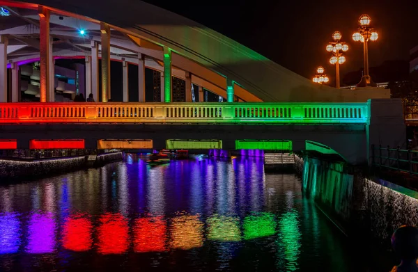 Rainbow colors illuminate a bridge at night in Singapore