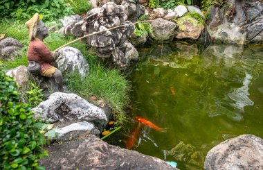 Statue and fish at Wat Pho Buddhist Temple in Bangkok