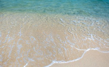 Temiz su ve yumuşak dalgalar Tayland 'da tropikal bir sahilde kırılıyor.