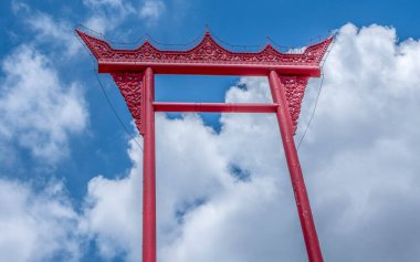 Clouds and blue sky and the giant red swing at Wat Suthat Buddhist Temple in Bangkok Thailand