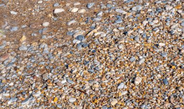 Yunanistan 'ın Sifnos adasında çakıl taşlarıyla kaplı bir plajda hafif dalgalar