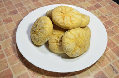 Masadaki beyaz tabakta yuvarlak kurabiyeler.