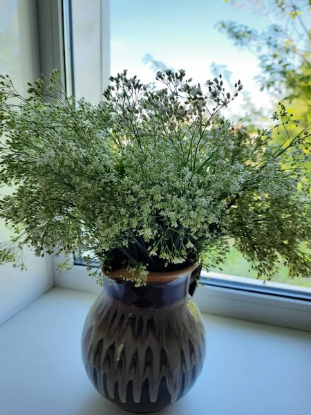 Penceredeki vazoda bir buket yabani çiçek.