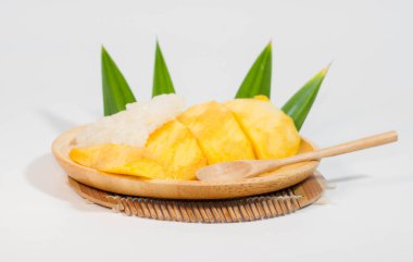 Tahta bir tabakta mango pilavı ve tahta bir kaşık, beyaz arka plan..