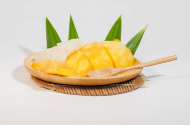 Tahta bir tabakta mango pilavı ve tahta bir kaşık, beyaz arka plan..