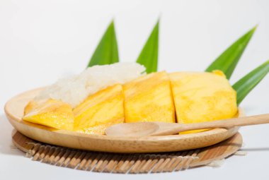 Tahta bir tabakta mango pilavı ve tahta bir kaşık, beyaz arka plan..