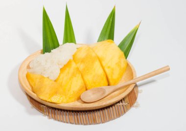 Tahta bir tabakta mango pilavı ve tahta bir kaşık, beyaz arka plan..