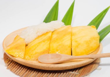 Tahta bir tabakta mango pilavı ve tahta bir kaşık, beyaz arka plan..